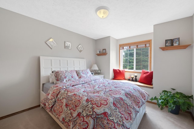 carpeted bedroom featuring baseboards and a textured ceiling