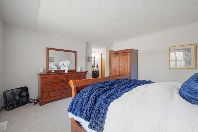 bedroom featuring a textured ceiling and light carpet