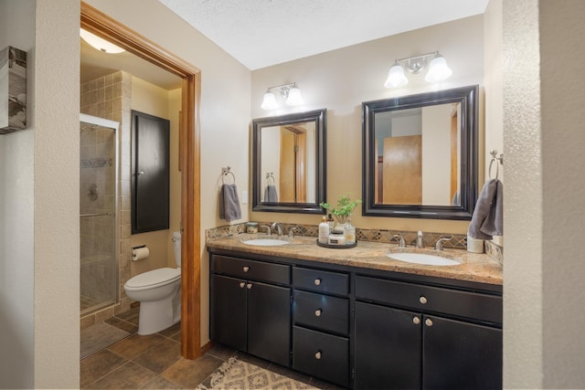 bathroom featuring double vanity, a stall shower, and a sink