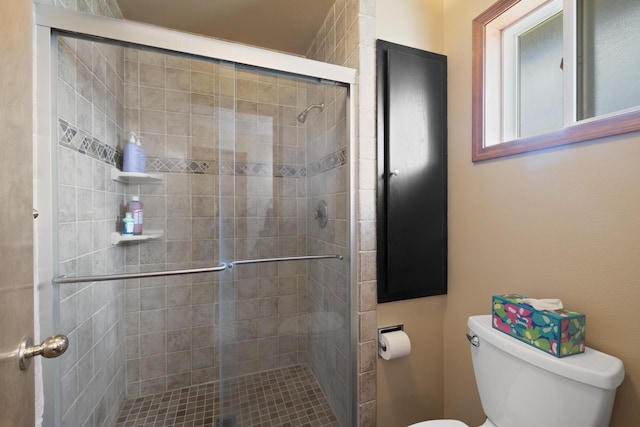 bathroom with a shower stall and toilet