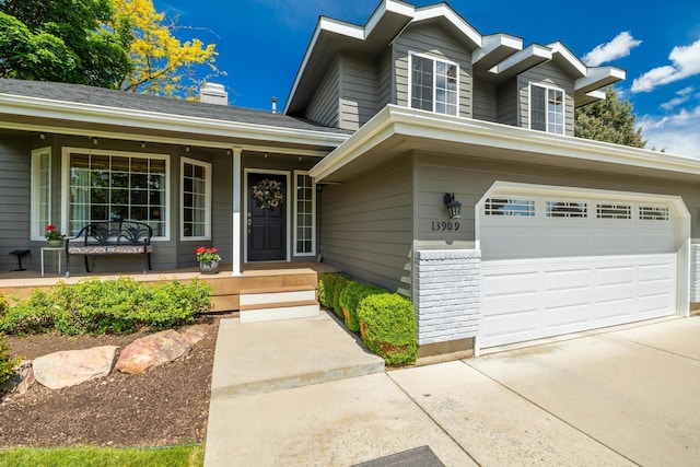 view of front of house featuring a garage, covered porch, and concrete driveway