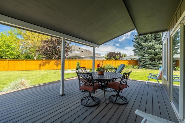 deck featuring a lawn, a fenced backyard, and outdoor dining space