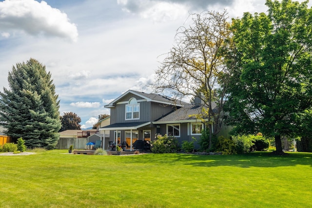 back of property with a yard and fence