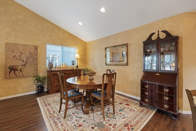 dining room featuring wood finished floors, baseboards, and vaulted ceiling