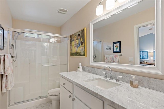 full bathroom with visible vents, a shower stall, toilet, and vanity