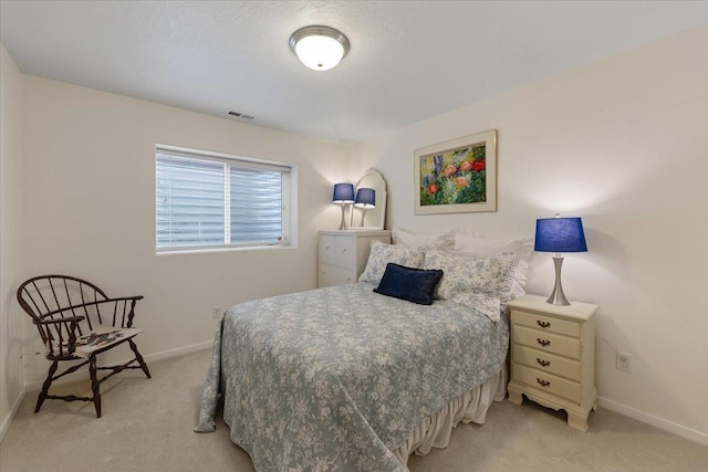 bedroom with light carpet, visible vents, and baseboards