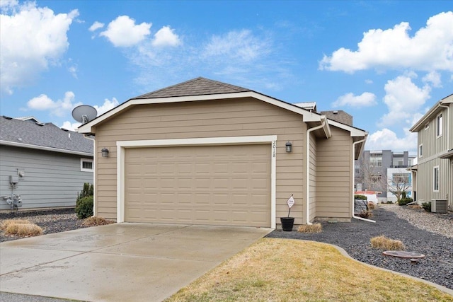 garage featuring central air condition unit and driveway