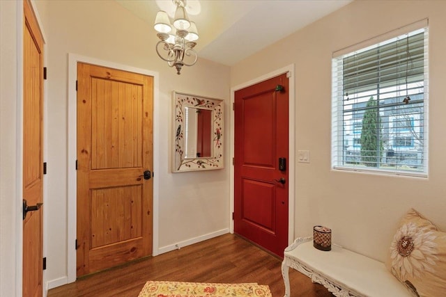 entryway with a notable chandelier, baseboards, and dark wood-type flooring