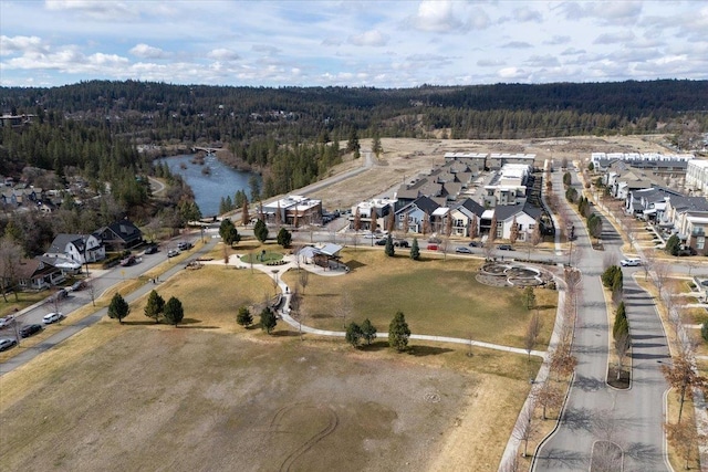 birds eye view of property with a wooded view and a water view