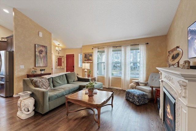 living room with a glass covered fireplace, vaulted ceiling, and wood finished floors