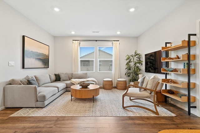 living area with recessed lighting, visible vents, baseboards, and wood finished floors