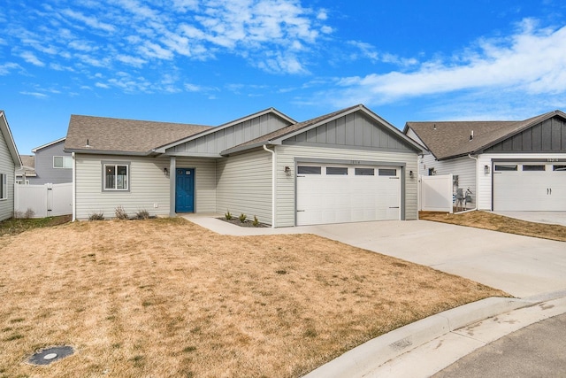 ranch-style house featuring a gate, fence, an attached garage, concrete driveway, and board and batten siding