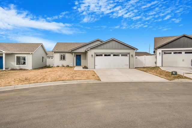 view of front of home featuring fence, concrete driveway, an attached garage, and a gate