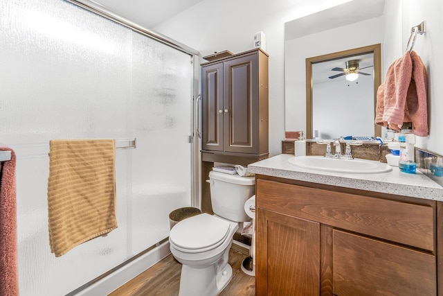 full bathroom with toilet, a stall shower, vanity, and wood finished floors