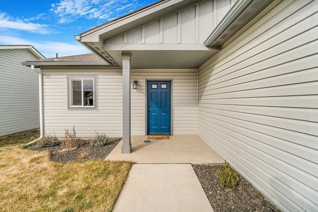 entrance to property with a lawn and board and batten siding