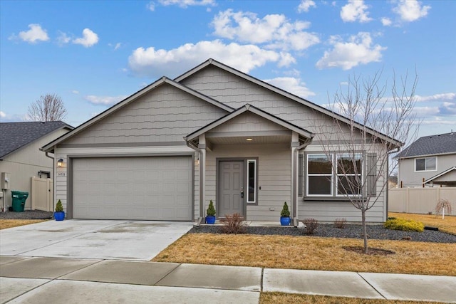 view of front facade with a garage, concrete driveway, and fence