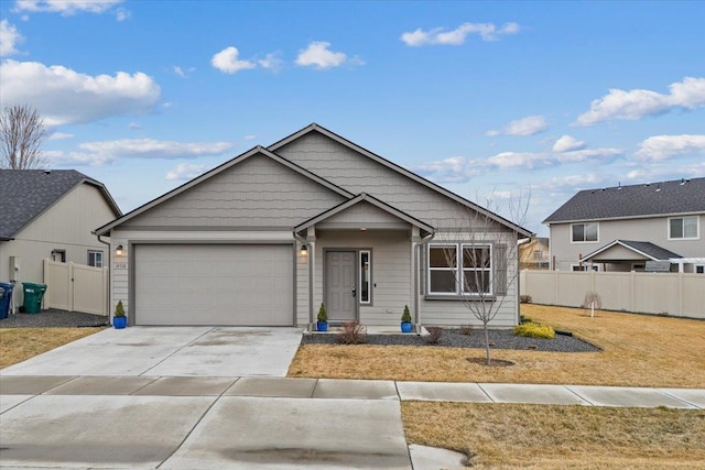 view of front of house with a front yard, an attached garage, fence, and driveway