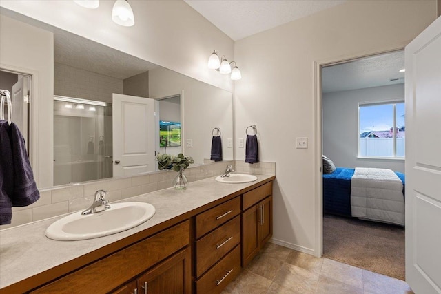 ensuite bathroom featuring a sink, connected bathroom, a shower with shower door, and double vanity