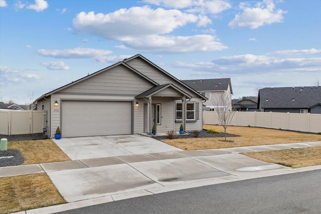 ranch-style home featuring an attached garage, a front lawn, fence, driveway, and a gate