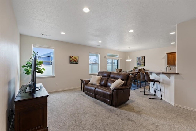 living room featuring plenty of natural light, light colored carpet, and baseboards