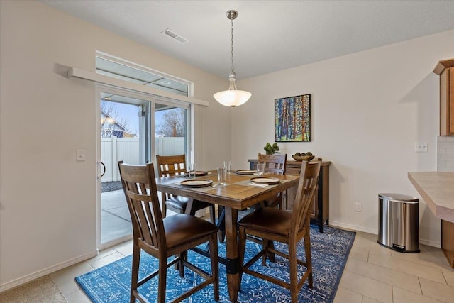 dining room with light tile patterned floors, visible vents, and baseboards