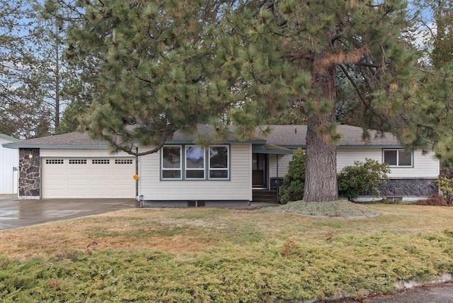 ranch-style home featuring a garage, concrete driveway, a front lawn, and a shingled roof