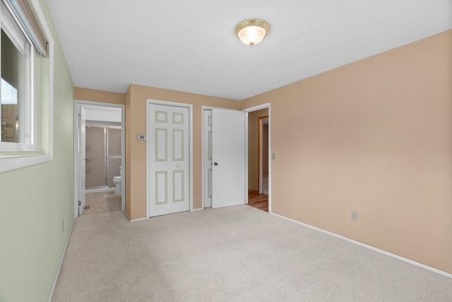 unfurnished bedroom with a closet, carpet flooring, and baseboards