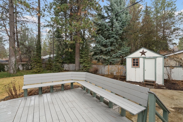 wooden deck with fence, an outdoor structure, and a shed