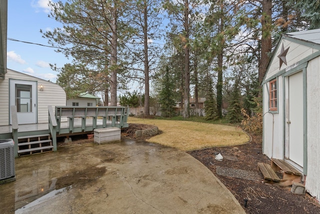 view of yard with a deck, central AC unit, a patio area, and fence