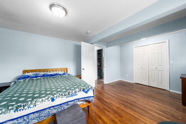 bedroom with a closet, baseboards, and wood finished floors