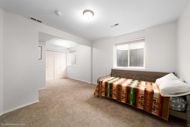 bedroom featuring visible vents, baseboards, and carpet