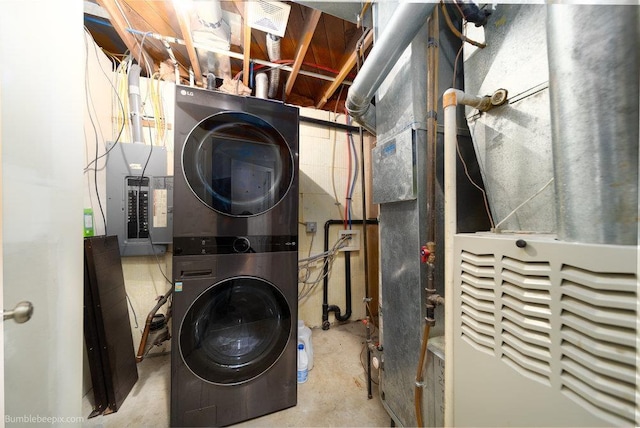 laundry room featuring electric panel, stacked washer and dryer, and laundry area