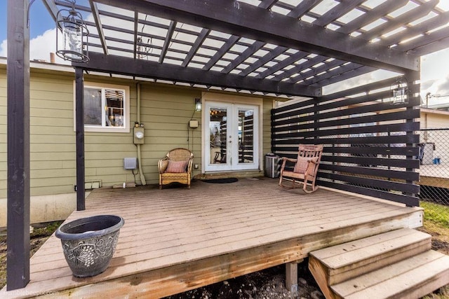 wooden terrace featuring fence, french doors, and a pergola