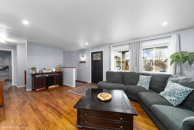 living room featuring recessed lighting, baseboards, and wood finished floors