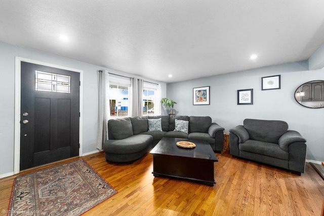 living room featuring recessed lighting, light wood-type flooring, and baseboards