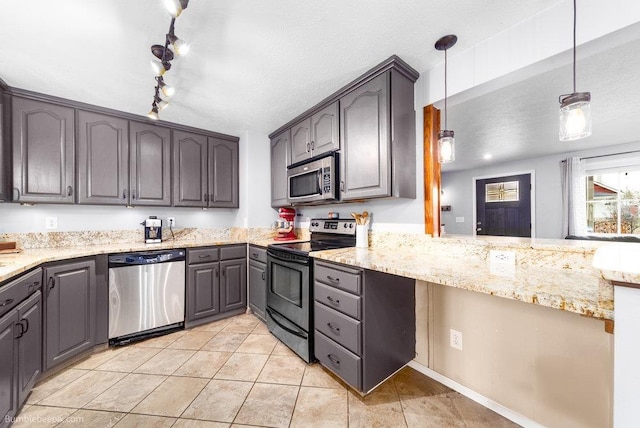 kitchen with light stone counters, a textured ceiling, appliances with stainless steel finishes, and light tile patterned floors