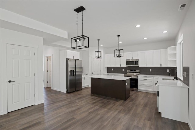 kitchen featuring visible vents, a sink, a center island, stainless steel appliances, and open shelves