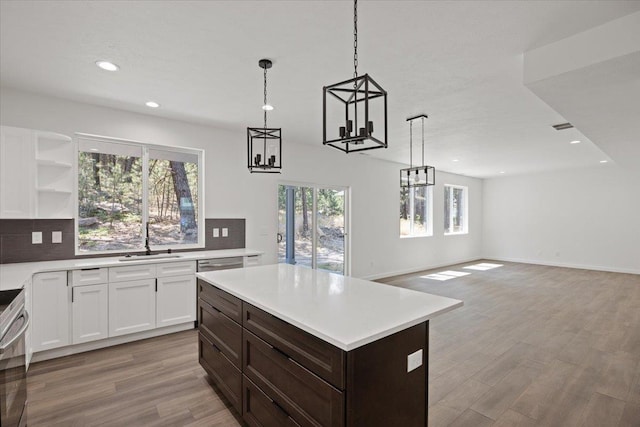 kitchen with backsplash, a notable chandelier, and light countertops