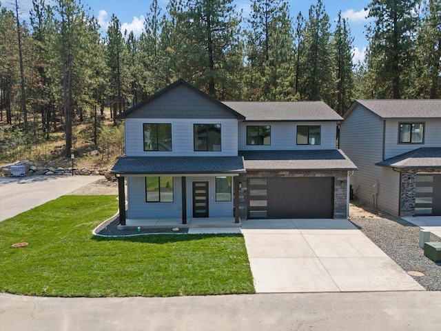 view of front of house with driveway, a porch, roof with shingles, a front yard, and a garage