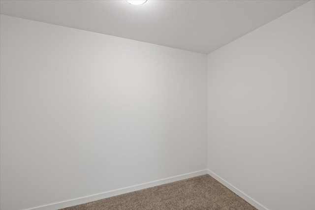 carpeted empty room with baseboards