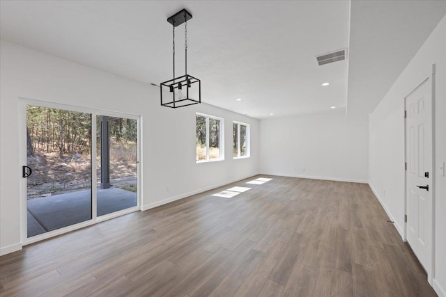 interior space with wood finished floors, visible vents, baseboards, an inviting chandelier, and recessed lighting