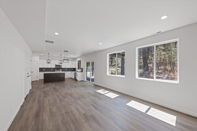 unfurnished living room with visible vents, recessed lighting, baseboards, and dark wood-style flooring