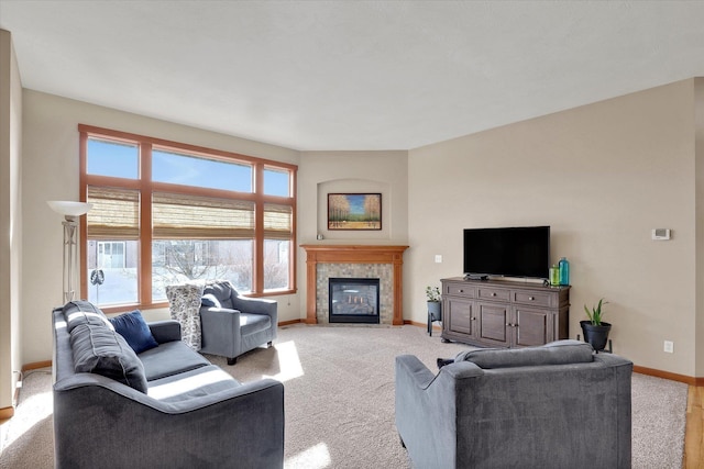 living area featuring a tiled fireplace, light carpet, and baseboards