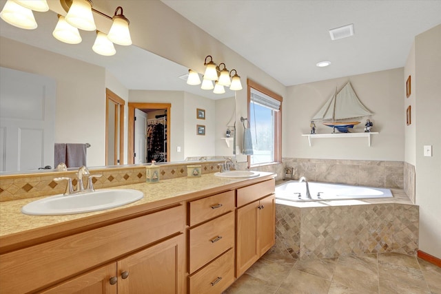 full bath with a sink, a walk in closet, a garden tub, and double vanity