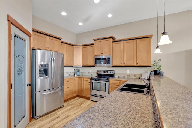 kitchen featuring a sink, light wood-style flooring, light brown cabinetry, and stainless steel appliances