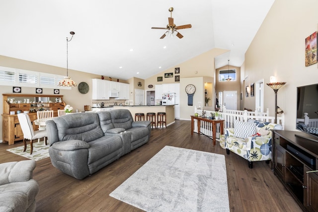 living room featuring dark wood-style floors, ceiling fan with notable chandelier, and high vaulted ceiling