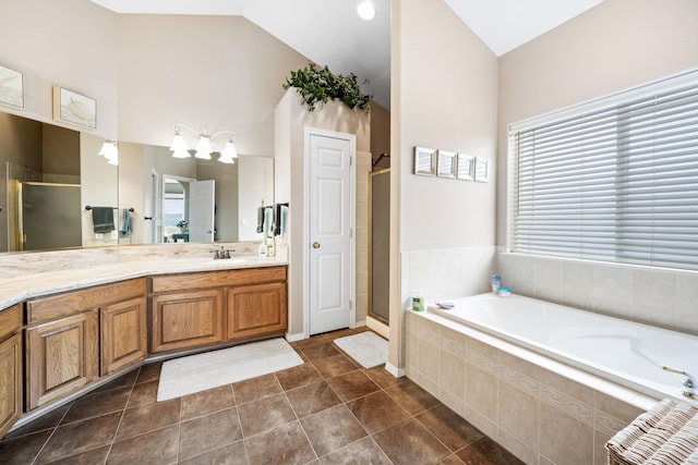 bathroom with a shower stall, tile patterned flooring, lofted ceiling, a bath, and vanity