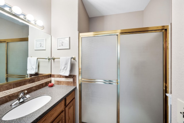 bathroom with a shower with shower door and vanity