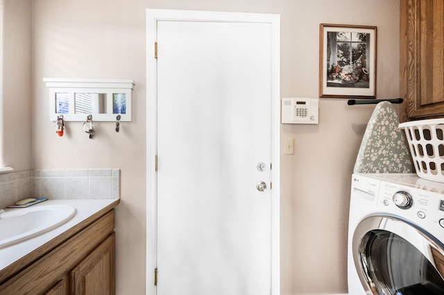 clothes washing area with laundry area, washer / clothes dryer, and a sink