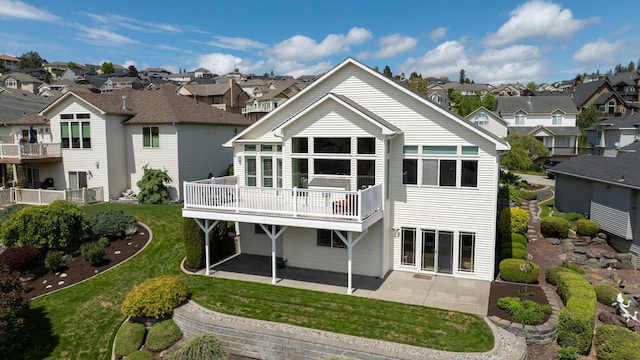 rear view of house featuring a residential view, a lawn, and a patio area